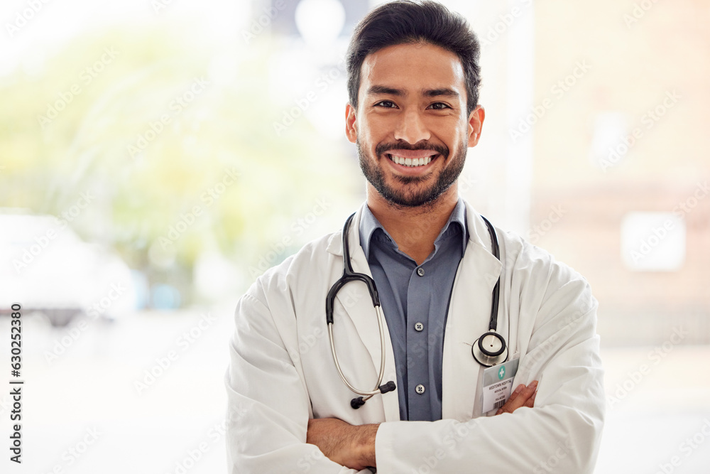 Portrait, smile and asian man doctor with arms crossed in hospital with stethoscope for consulting o