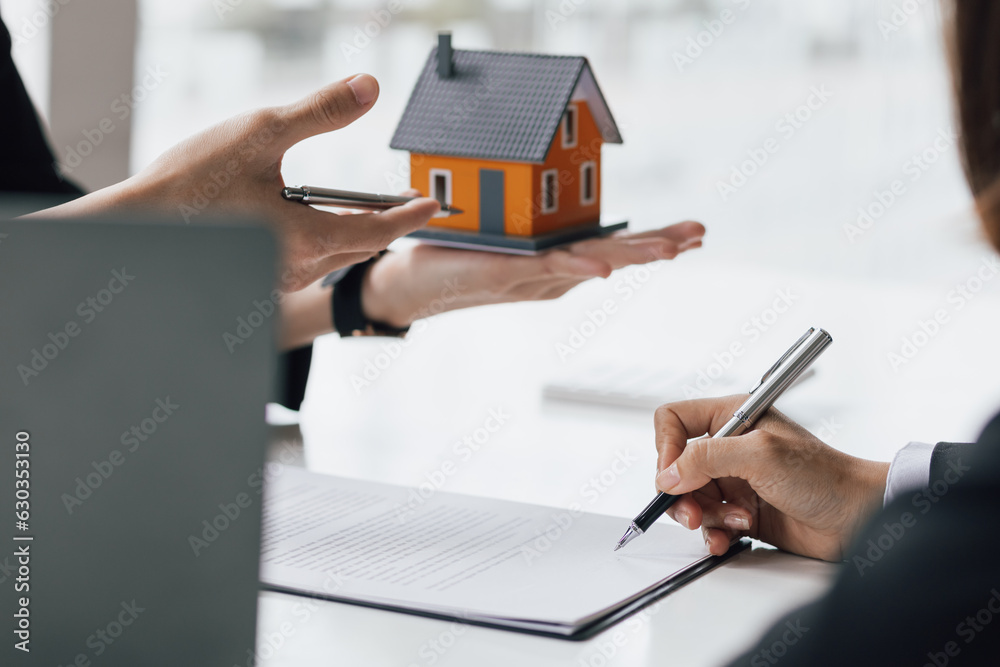 Real estate agents discuss the house and sign a home purchase agreement, mortgage, rent, lease.