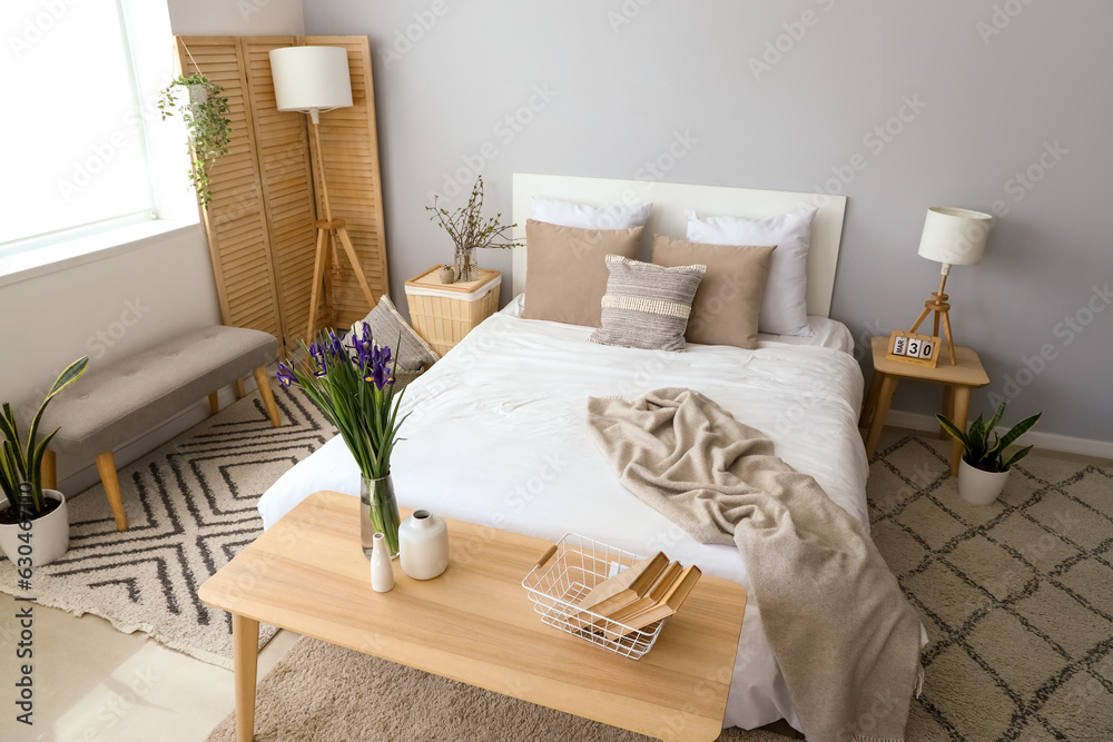 Interior of light living room with blooming iris flowers on table