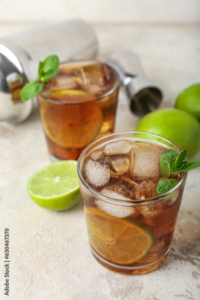 Glasses of tasty Cuba Libre cocktail on light background