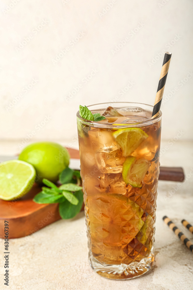 Glass of tasty Cuba Libre cocktail on light background