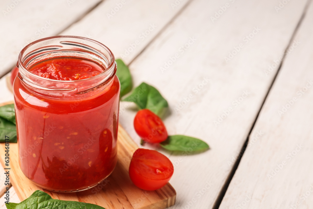 jar with tasty tomato sauce on light wooden background