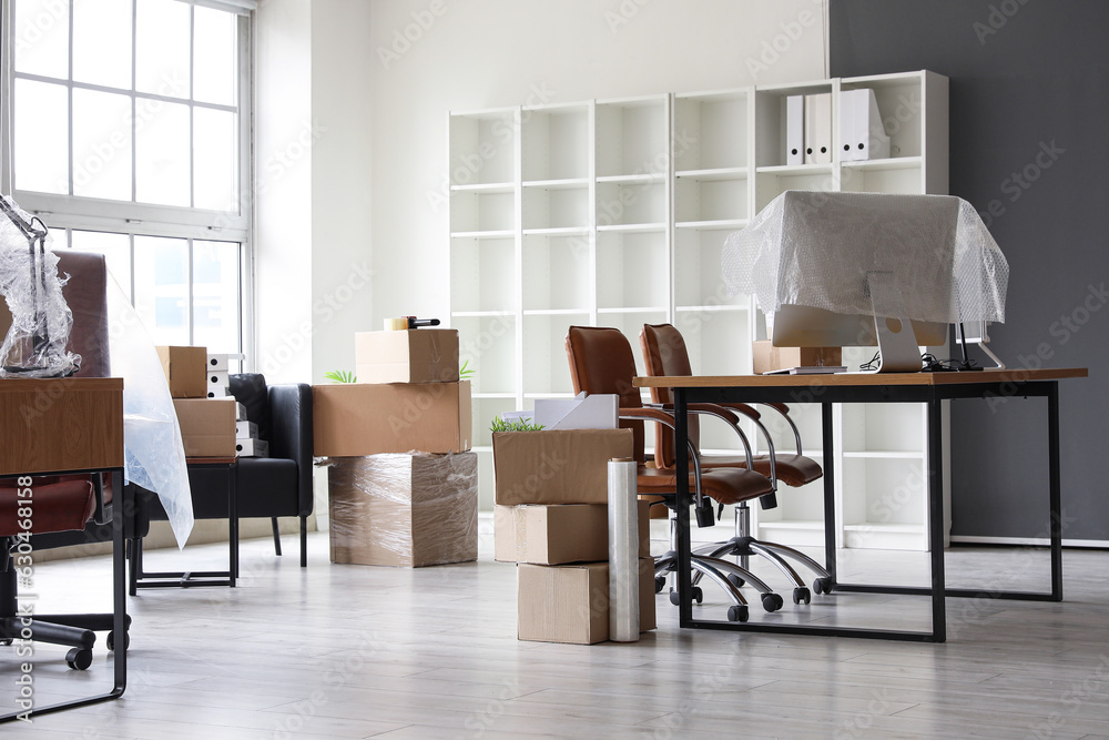 Workplace with cardboard boxes in office on moving day