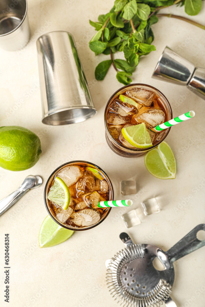 Glasses of cold Cuba Libre cocktail on light background