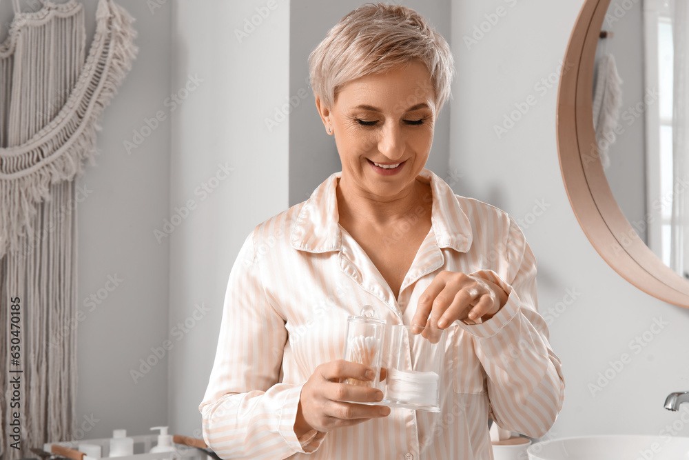 Mature woman with cotton buds and pads in bathroom