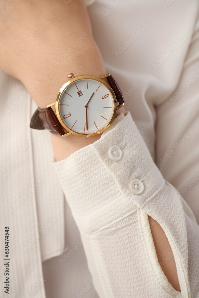 Elegant young woman with wristwatch, closeup