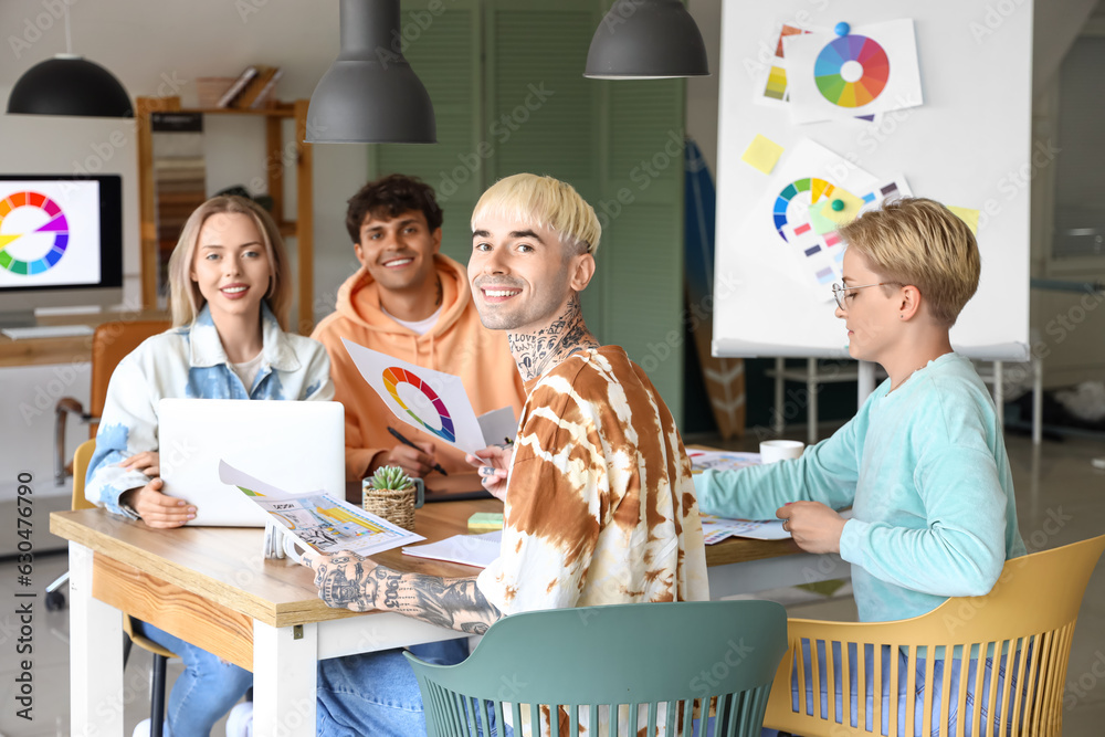 Team of graphic designers working at table in office