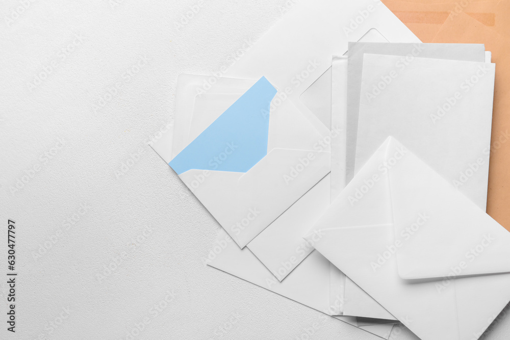 Heap of envelopes and card on light background