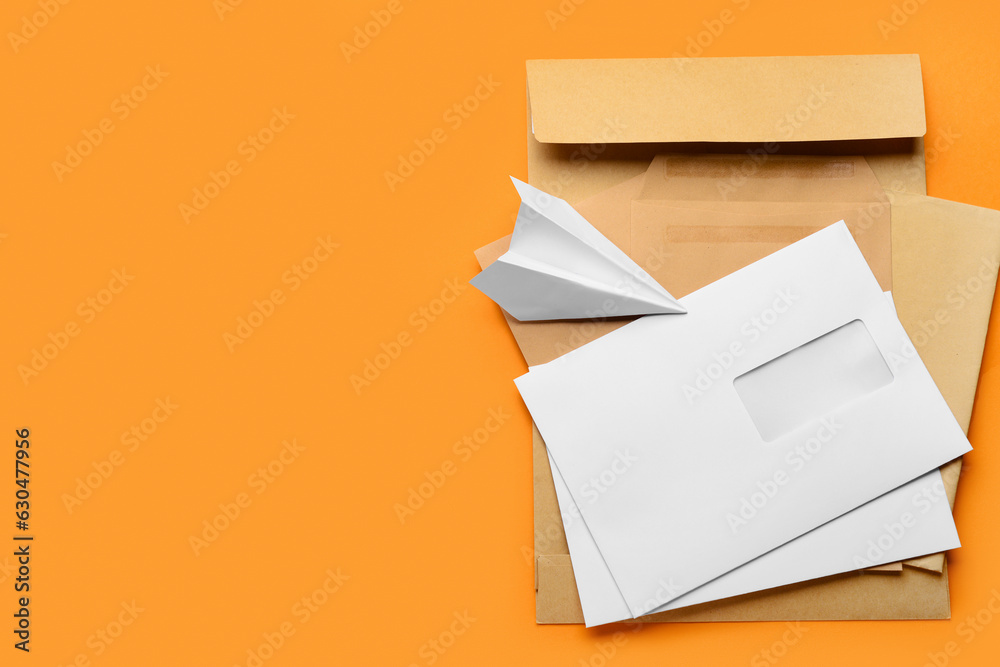 Different envelopes and paper plane on color background