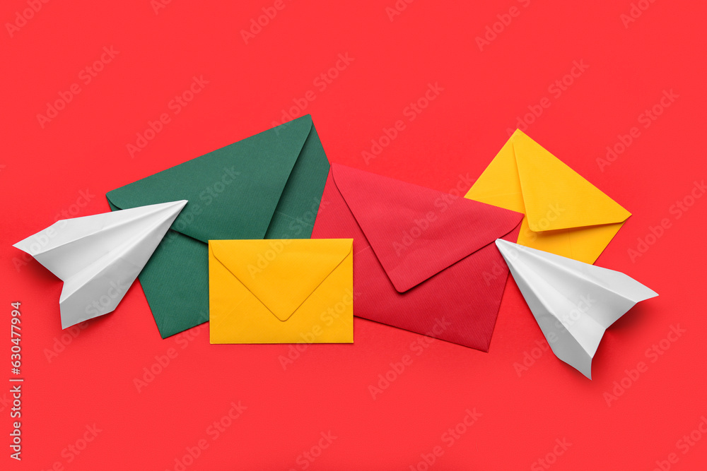 Set of different envelopes and paper planes on red background