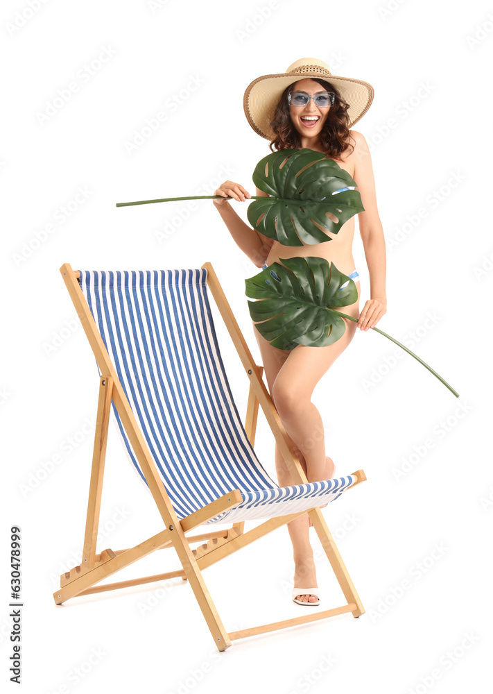 Young woman with palm leaves and deck chair on white background