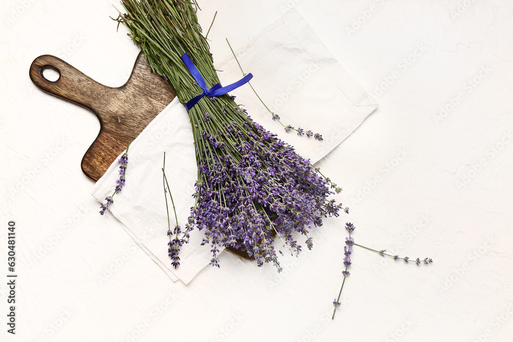 Board with bouquet of beautiful lavender flowers on light background