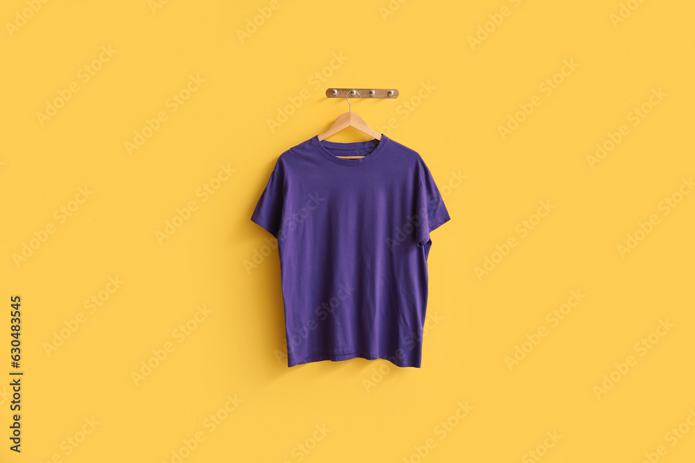 Stylish purple t-shirt hanging on yellow background