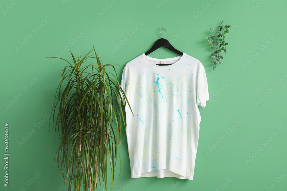 Stylish white t-shirt hanging on green background