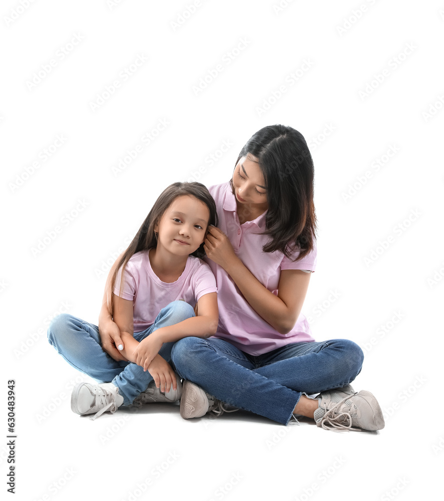 Asian mother with her little daughter hugging on white background