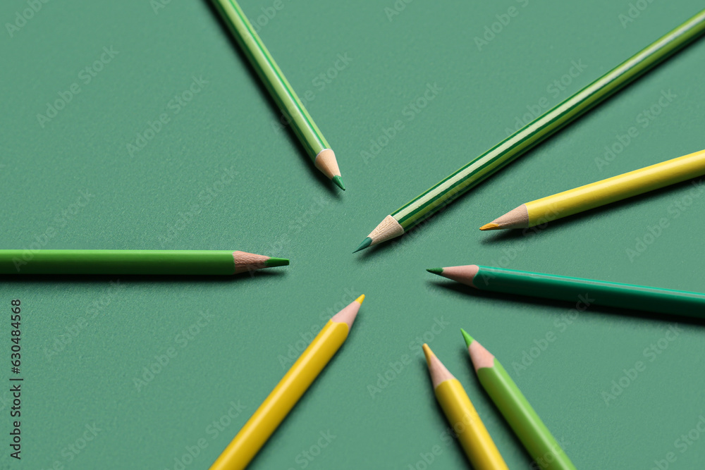 Set of color pencils on green background