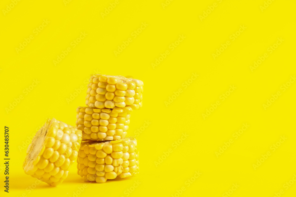 Cut fresh corn cob on yellow background