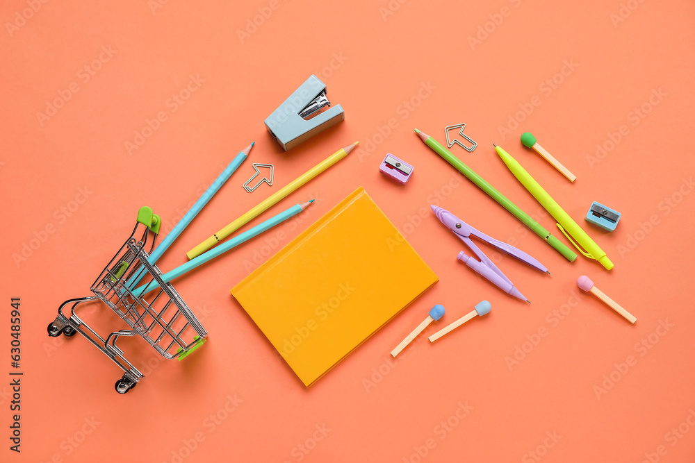 Shopping cart with different school stationery on orange background