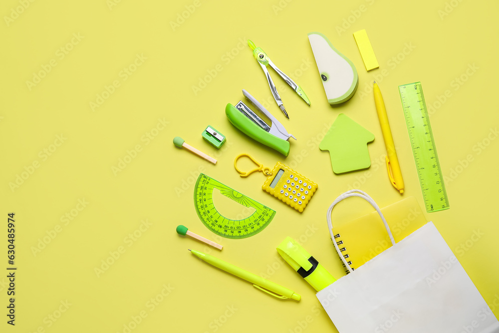 Shopping bag with different school stationery on yellow background