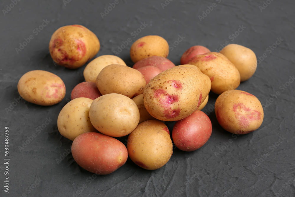 Fresh raw potatoes on black background