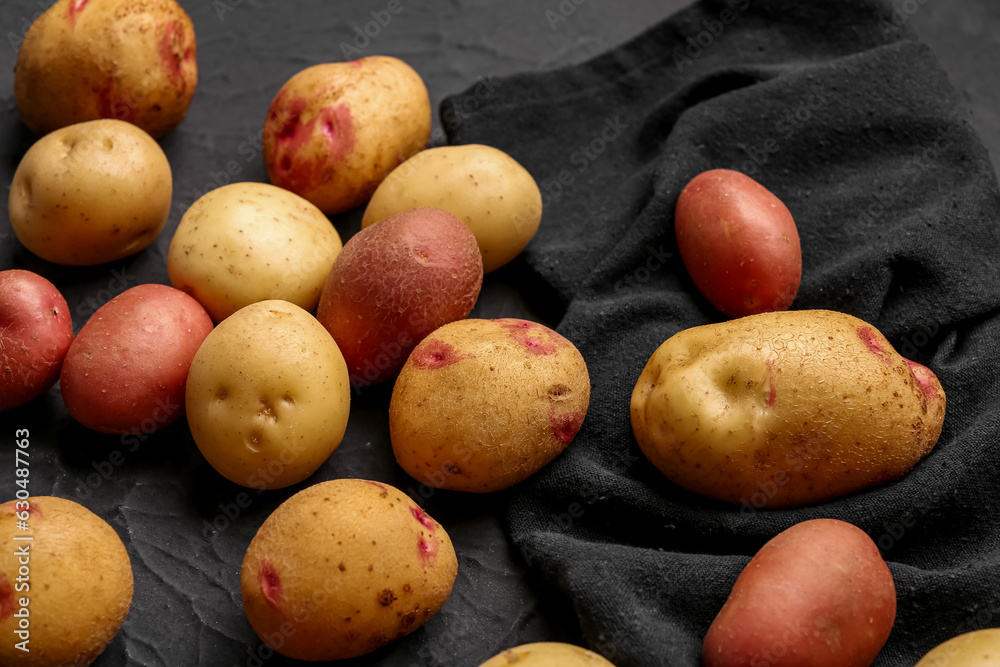 Fresh raw potatoes on black background