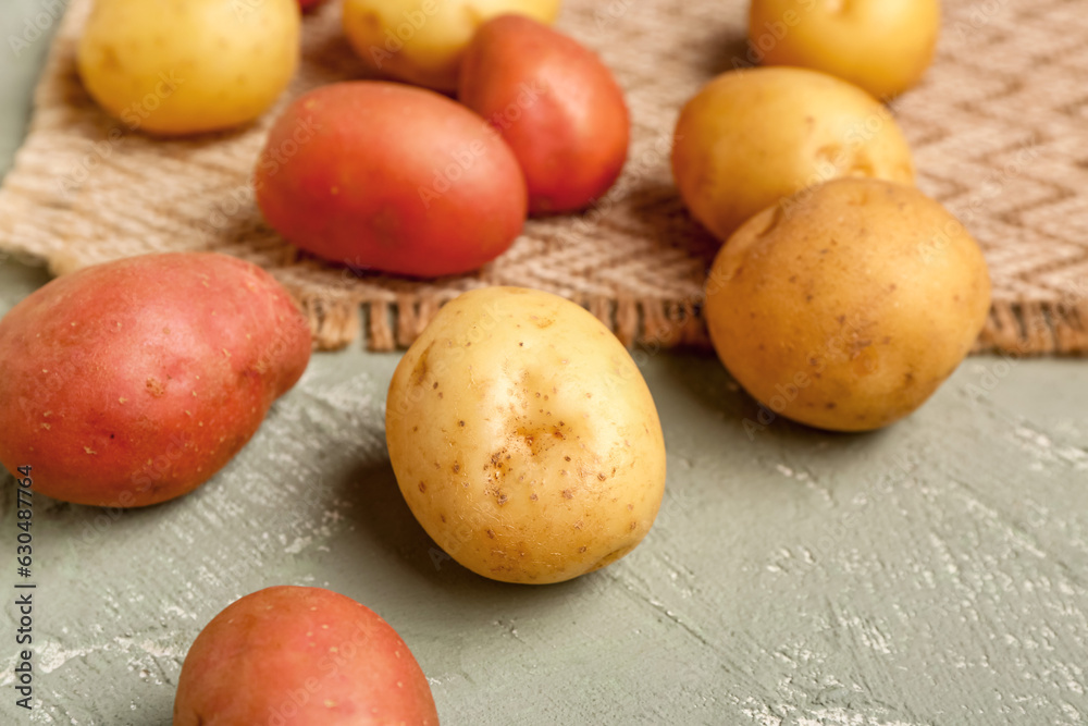 Fresh raw potatoes on grey background