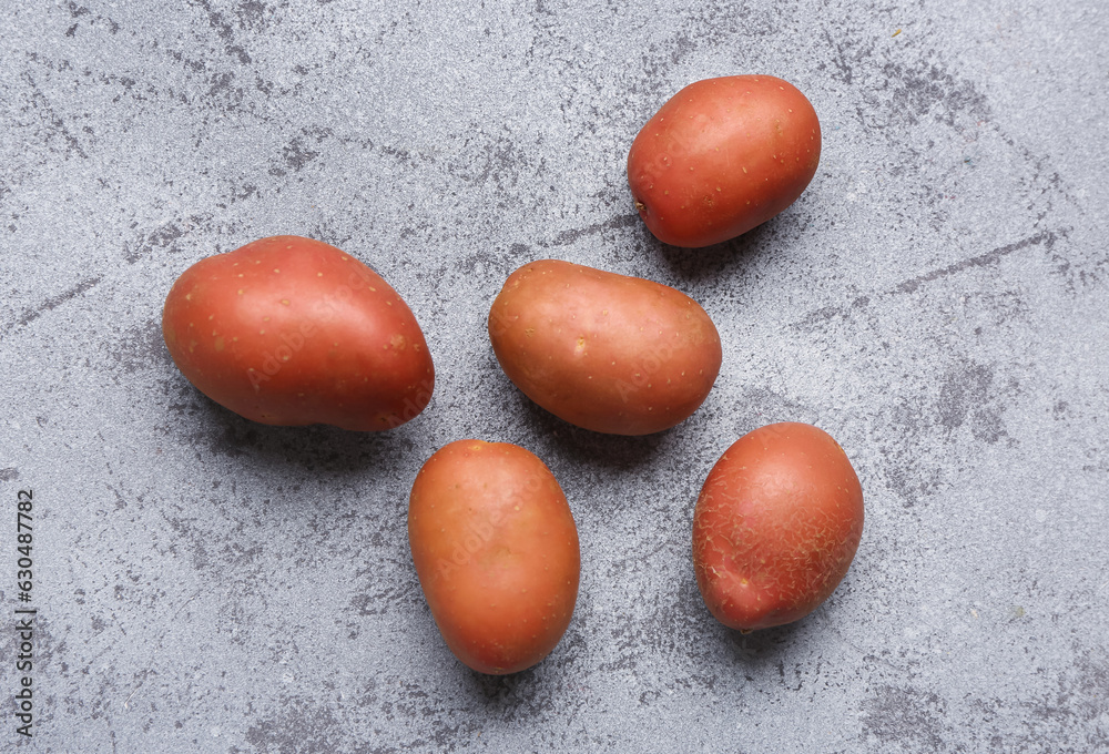 Fresh raw potatoes on blue background