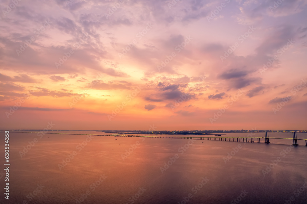 Aerial photo of Qingdao Jiaozhou Bay Cross Sea Bridge under sunset..