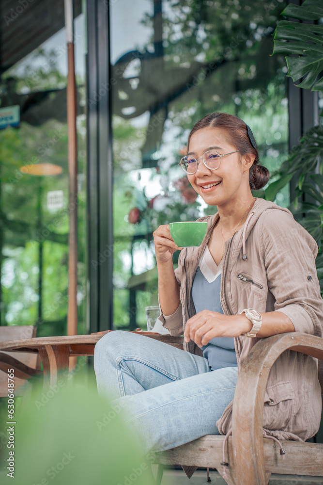 woman holding cup of cappuccino coffee in Coffee Shop.