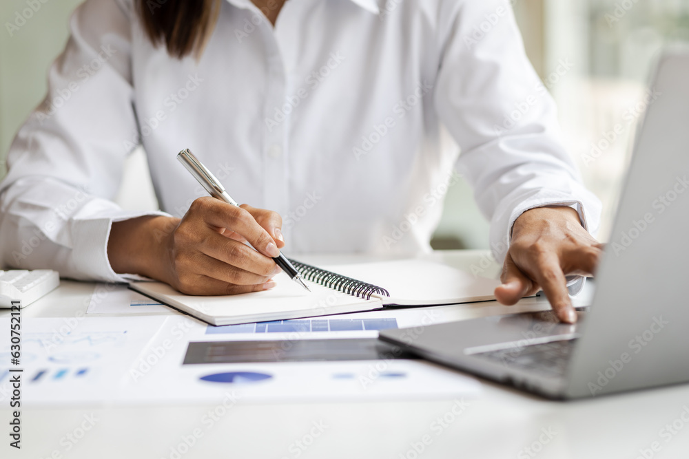 Businesswoman working with laptop and analyzing financial and accounting documents. Business woman w