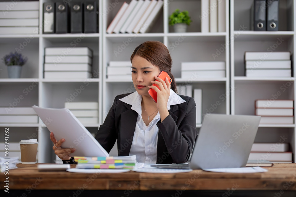 Serious focused manager consulting client talking on the phone making business call at work, young f