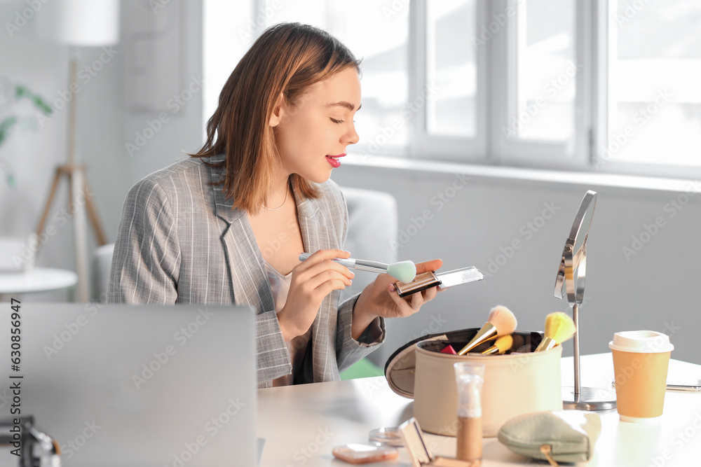 Female beauty blogger with makeup powder recording video at home