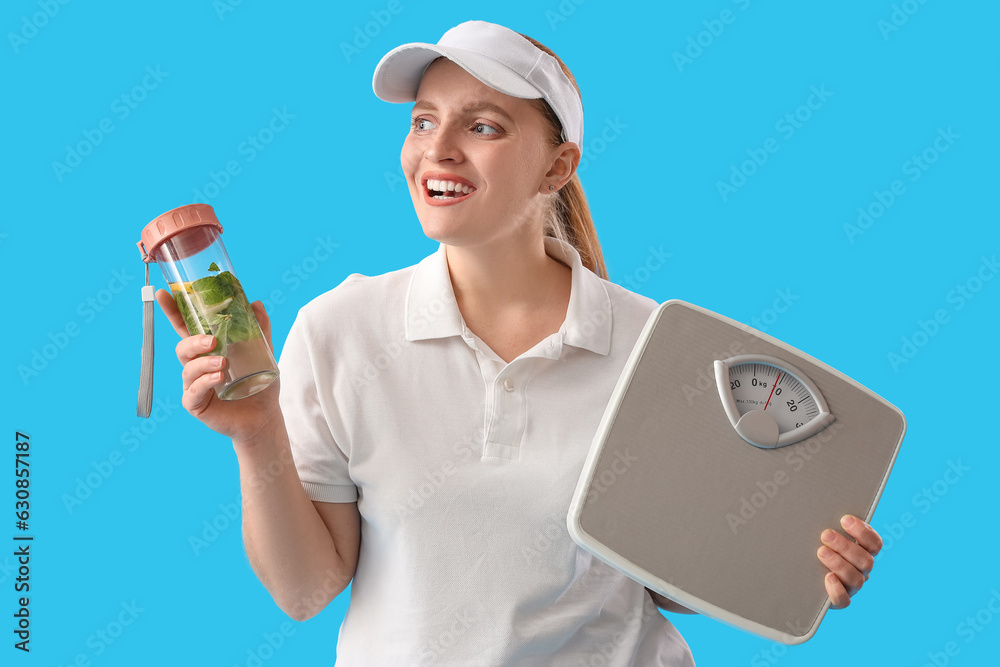 Young overweight woman with scales and bottle of water on blue background