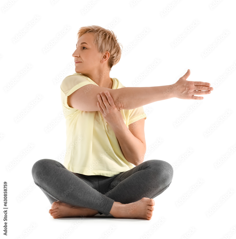 Sporty mature woman practicing yoga on white background