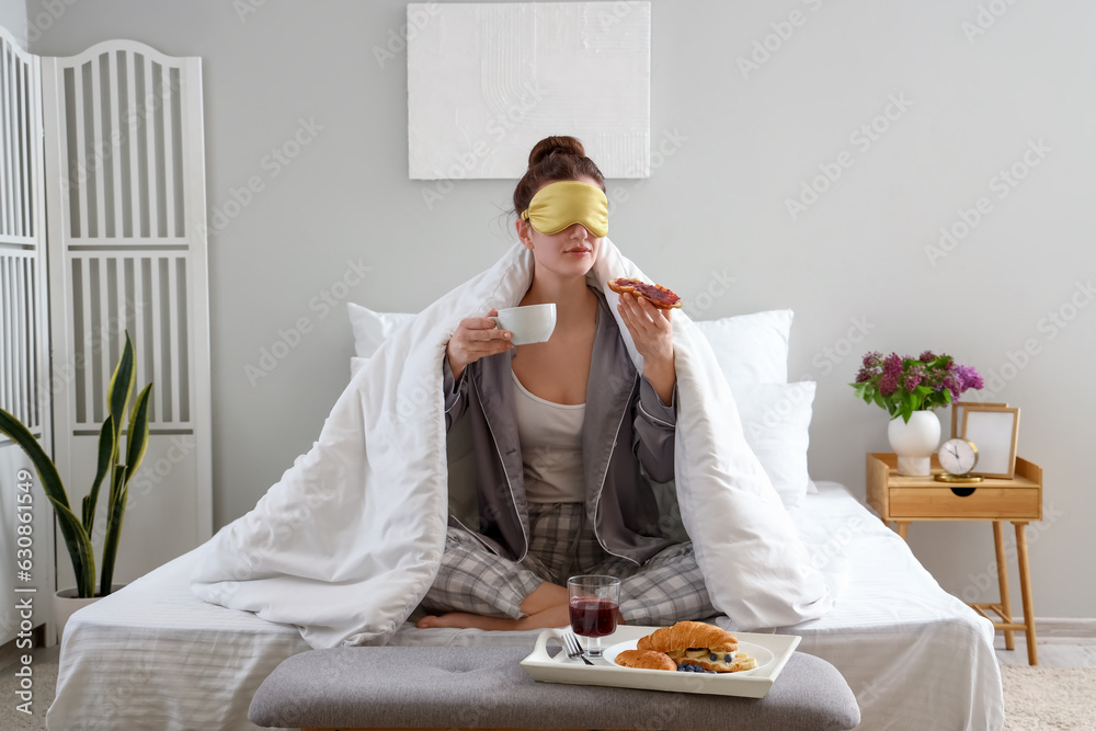 Morning of young woman having breakfast in bedroom