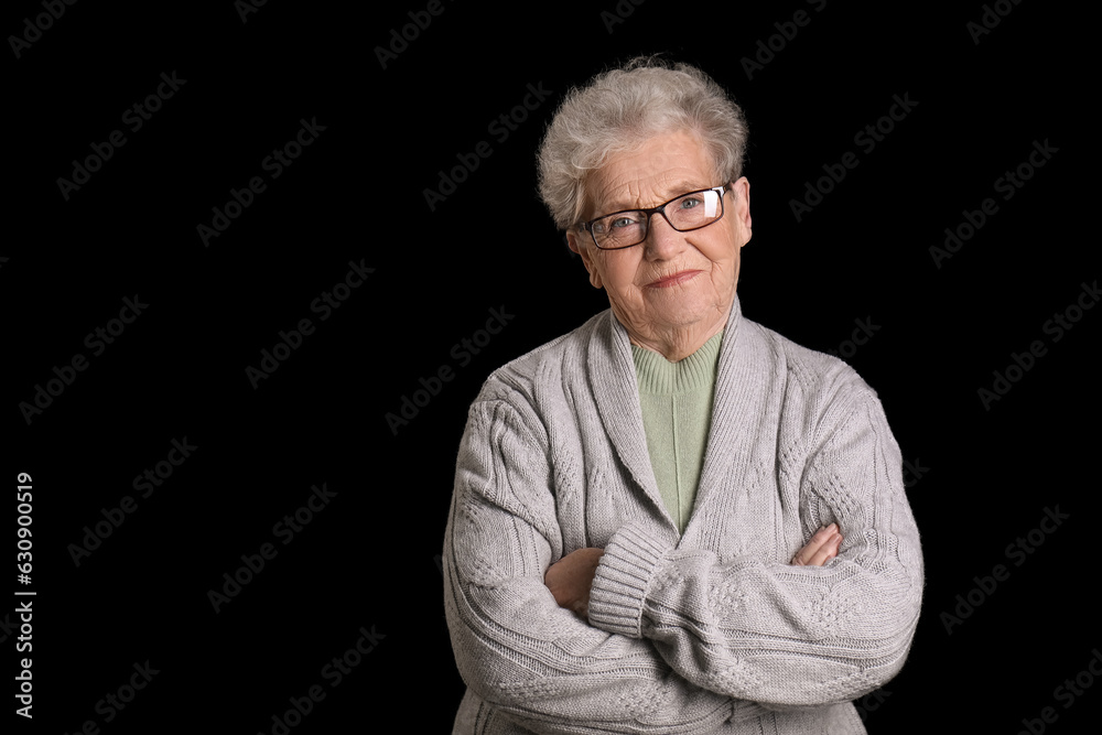 Senior woman in eyeglasses on black background