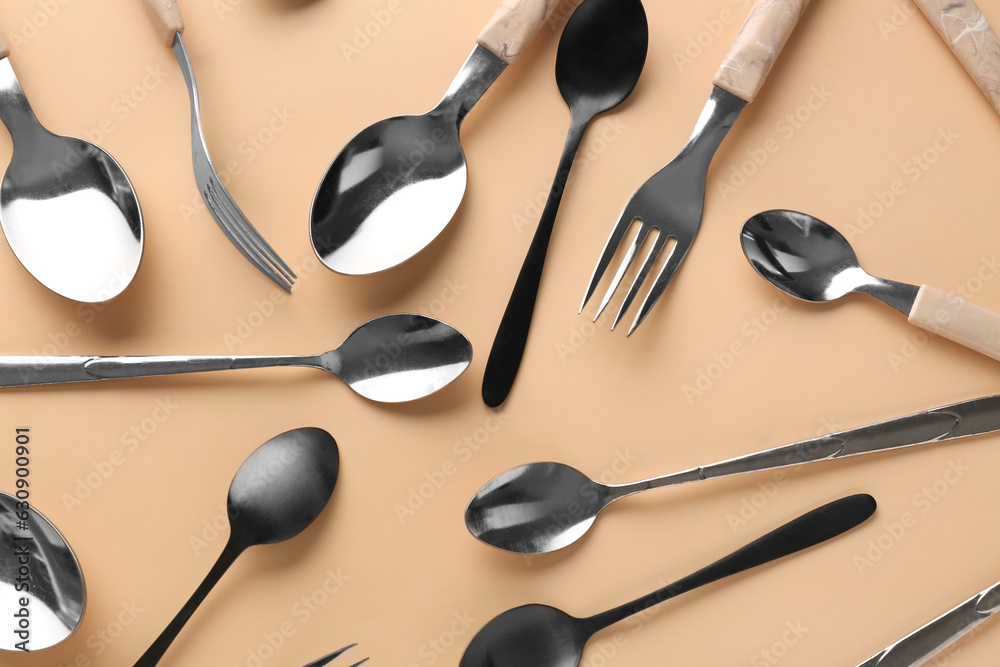 Silver and black cutlery on beige background