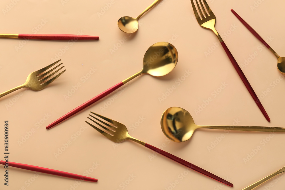 Golden cutlery on beige background