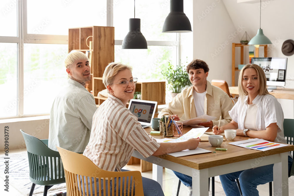 Team of graphic designers working at table in office