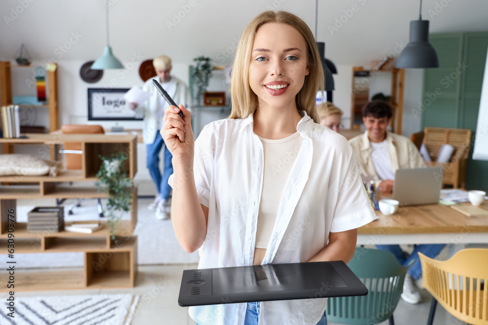 Female graphic designer with tablet working in office