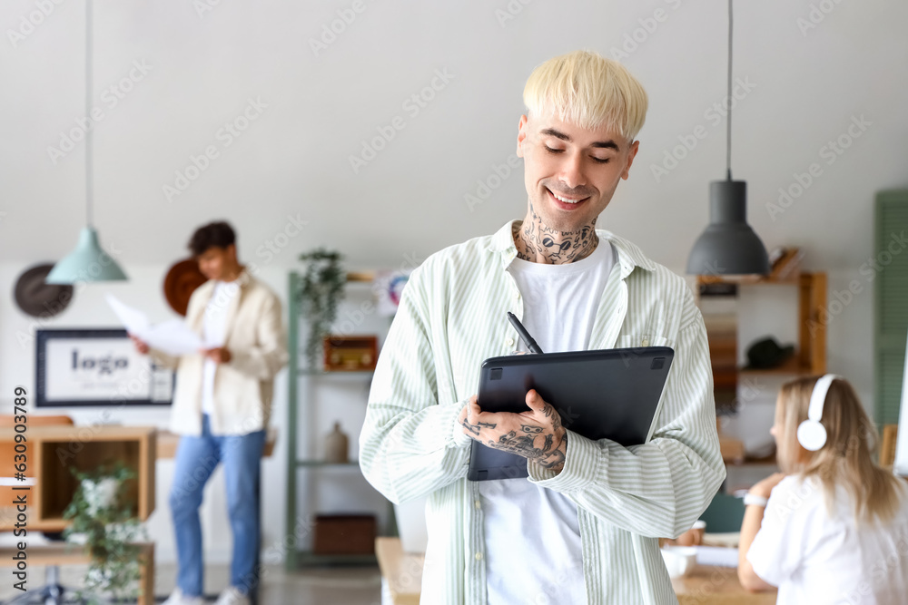 Male graphic designer working with tablet in office