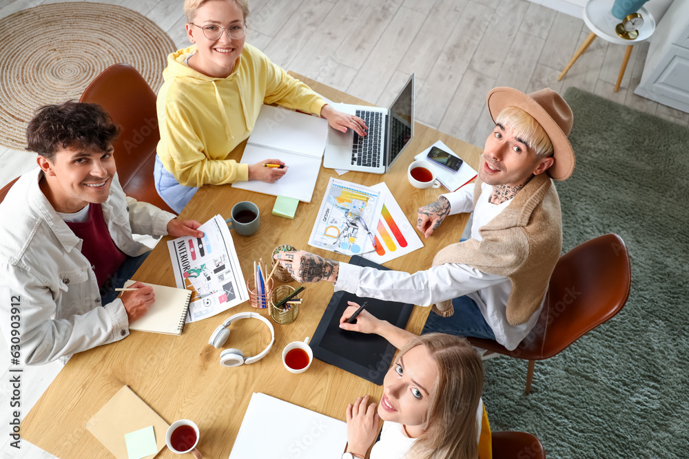 Team of graphic designers working at table in office, top view