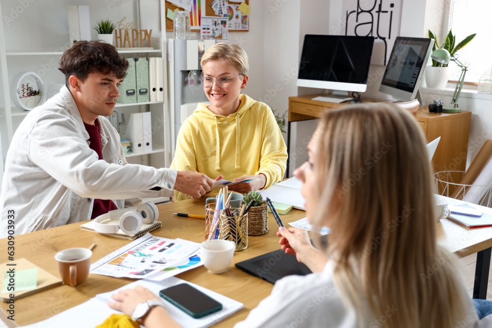 Team of graphic designers working at table in office