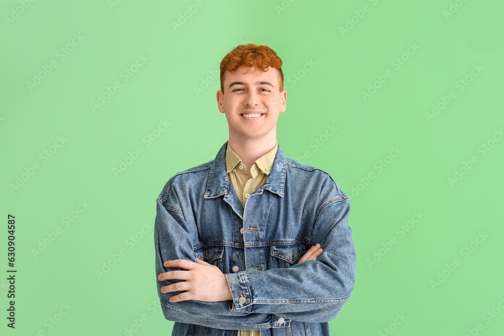 Young redhead man on green background