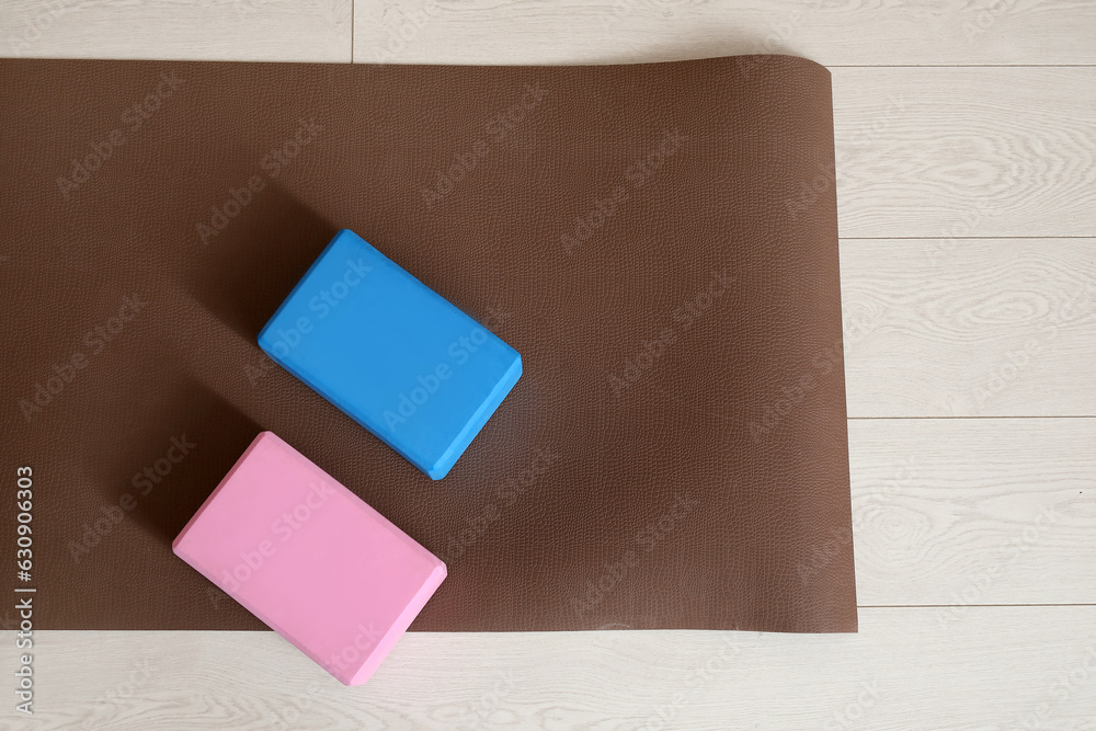 Blocks with yoga mat on floor, top view