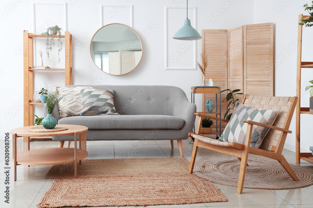 Interior of light living room with sofa, armchair and houseplants