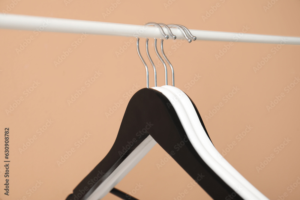 Rack with wooden clothes hangers on beige background