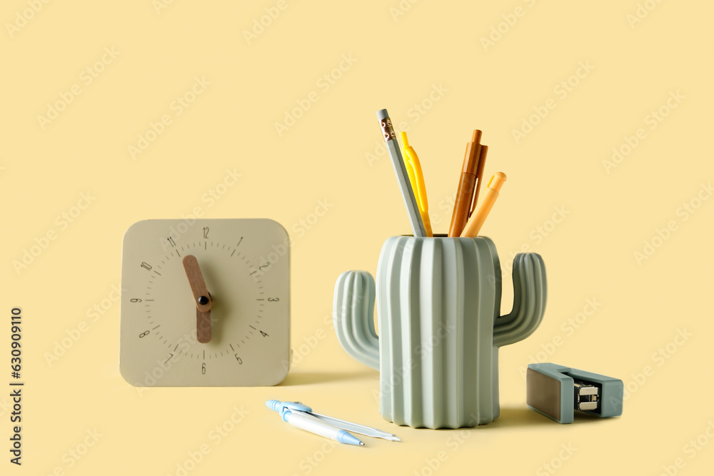 Stylish holder with stationery and clock on color background