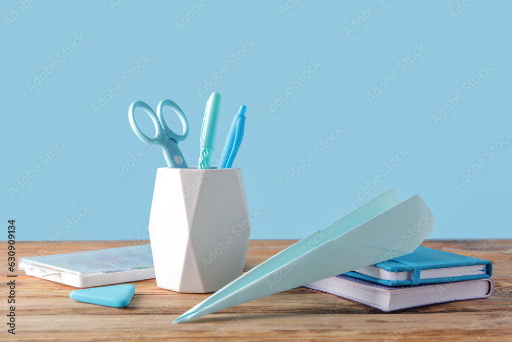 Set of stationery with paper plane on wooden table