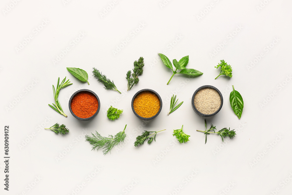 Composition with fresh herbs and different spices on light background